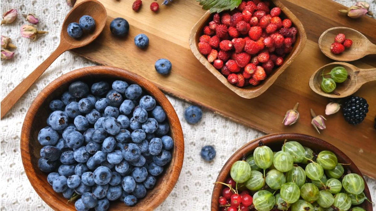 Fresh blueberries and berries in wooden bowls